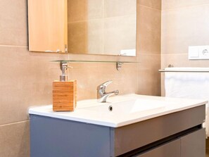 A bathroom with a white sink, a wooden soap dispenser, and a mirror above the sink. - Bia Serviced Apartments & Bia D'olaf (Sal)