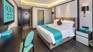 Een hotelkamer met een bed, nachtkastjes, een bureau en een stoel.