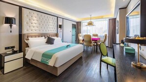 Een hotelkamer met een groot bed, een bureau, een stoel en een televisie.