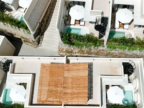 A rooftop terrace with a pool, sun loungers, and a wooden deck. - Drini Park Resort (Wonosari)