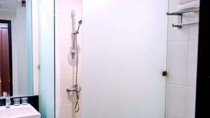 A bathroom with a sink, mirror, shower, and toilet. - Smart Hotel (Lubuklinggau)