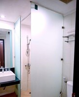 Un baño con lavamanos, espejo, ducha e inodoro.