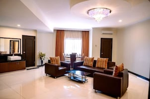 A spacious living area with a sofa set, a coffee table, and a chandelier.