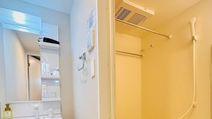 A bathroom with a white sink, mirror, and a bathtub with a showerhead. - Hotel Arashi Nambaminami No003 (Osaka)