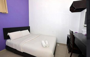 Una habitación de hotel con una cama, un escritorio y una silla.