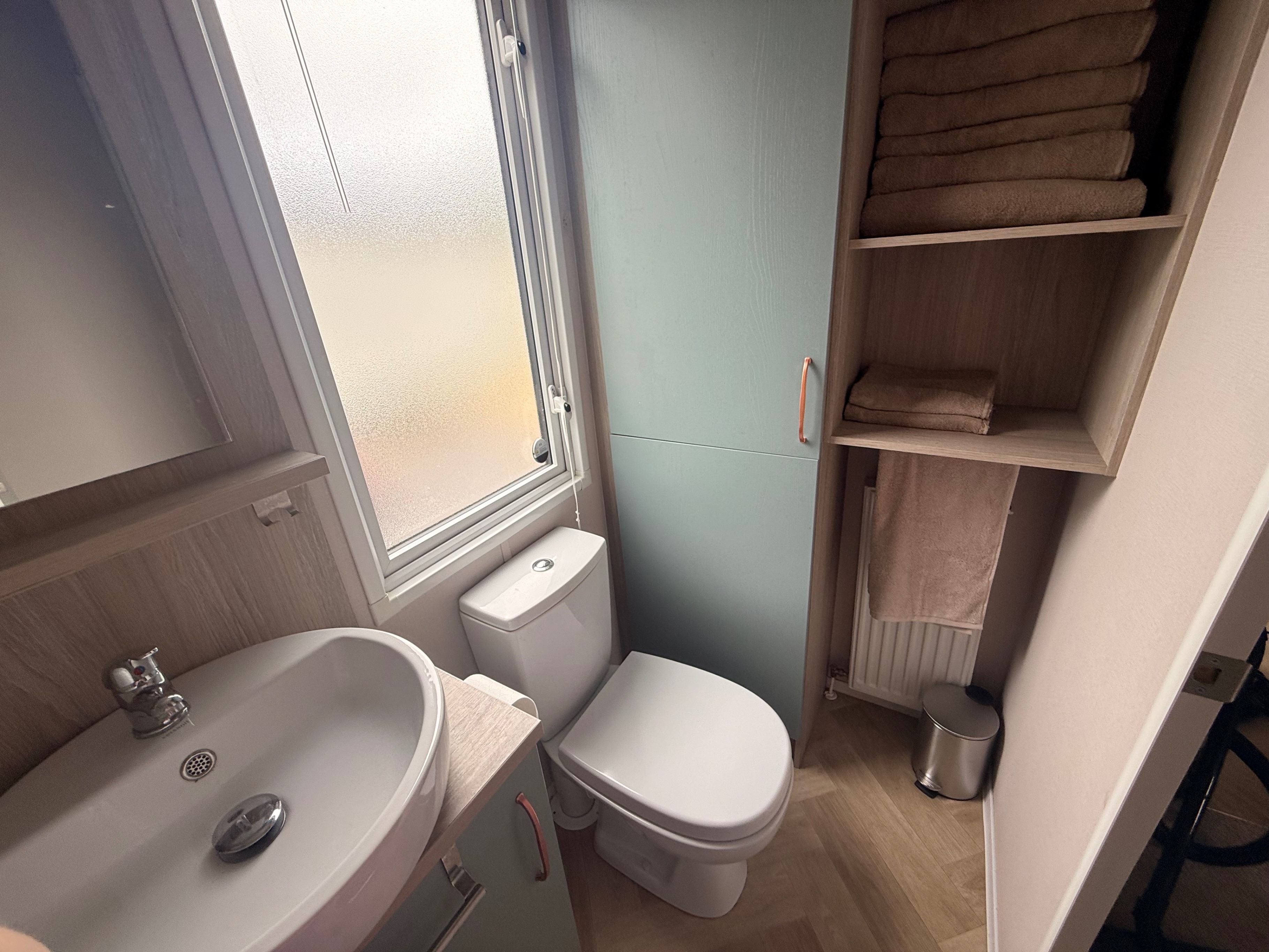 Un baño pequeño con lavamanos, inodoro y ventana.