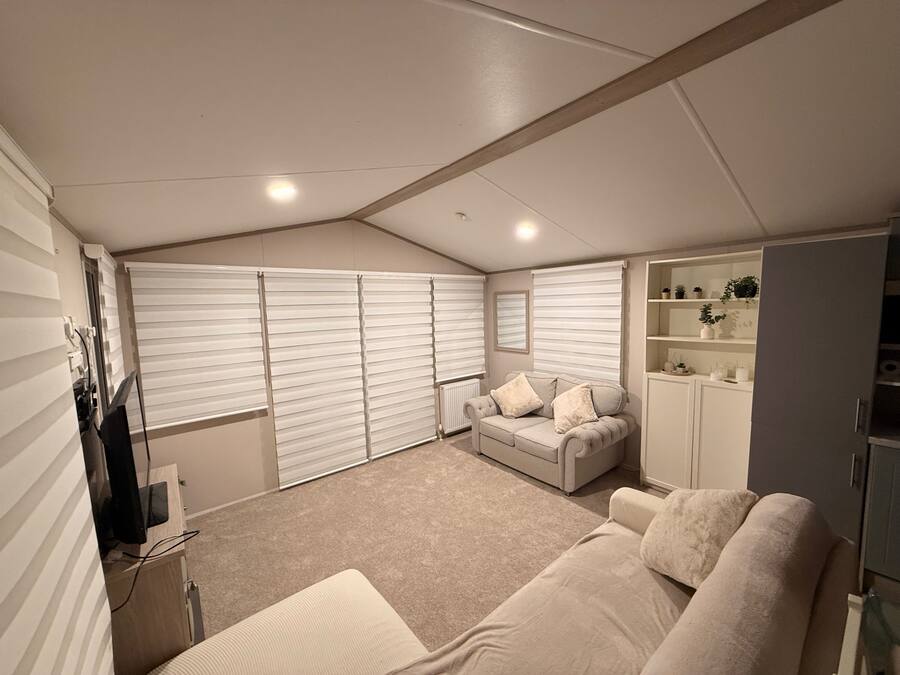 A bedroom with a bed, a sofa, a wardrobe, and a radiator.
