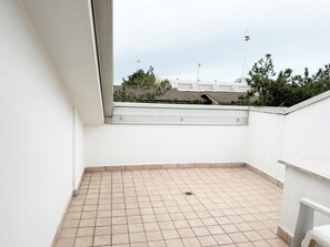 A small, enclosed balcony with tiled flooring and a white wall. - Duplex With Terrace Close to Beach (San Michele al Tagliamento)