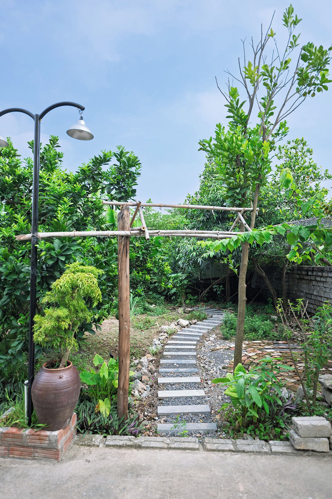 A garden pathway leading to a wooden structure with a metal frame.