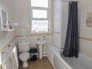 A bathroom with a toilet, sink, and bathtub. - Cosy Escape (Birmingham)