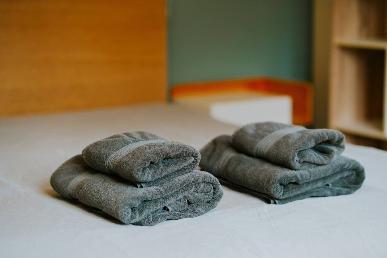 Una cama bien hecha con toallas dobladas.