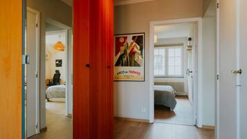 Hotelkamer met een bed, een bureau en een stoel. Een poster hangt aan de muur en er is een raam met uitzicht op buiten.
