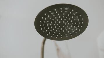 Un pommeau de douche au design circulaire, doté de plusieurs petits trous.