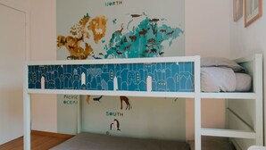 Uma cama de beliche com um mural de mapa-múndi mostrando animais e regiões.