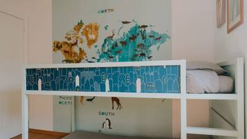 Un lit superposé avec une fresque représentant une carte du monde au-dessus, illustrant des animaux et différentes régions.