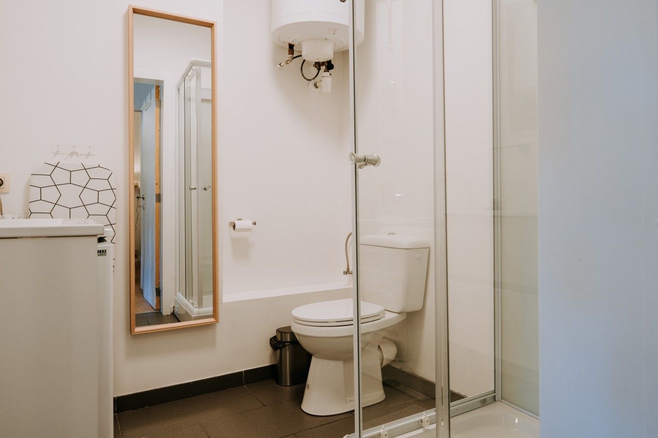 Et stilfuldt badeværelse med toilet, bruseniche og spejl.