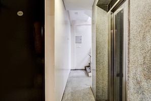 A hallway with a door marked '305', a staircase, and a wall-mounted light switch.