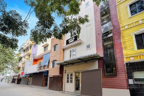 A multi-story hotel with a 'HOTEL' sign, a gated entrance, and a visible storefront.