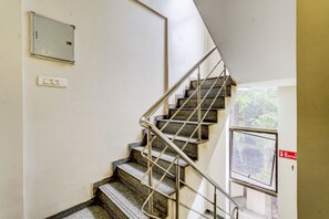 A staircase with metal railings and stone steps, leading to an upper floor.