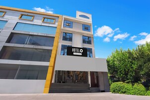 A hotel with a modern facade, a prominent sign, and a staircase leading to the entrance.