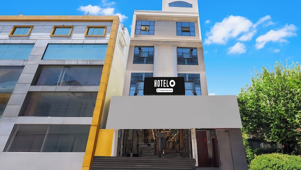 Ein Hotel mit modernem Design, ein auffälliges Schild und eine Treppe zum Eingang.