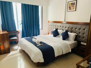Una habitación de hotel con una cama, un escritorio y una silla.