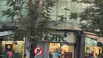 A street scene with a building that has a sign with non-English script, a no parking sign, and a staircase leading to the entrance.