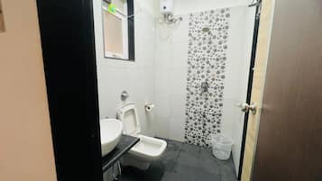 Casa de banho pequena com sanita, bidé e zona de duche.
