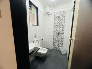 Casa de banho pequena com sanita, bidé e zona de duche.