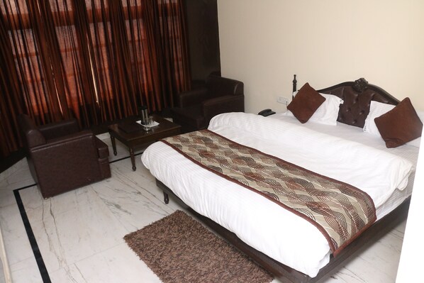 A hotel room with a bed, a desk, a chair, and a sofa. - The Grand Valley (Mussoorie)