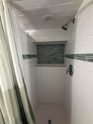A shower with white tiled walls and a green-tiled window. - Cozy Private Loft in Central Cochrane – Walk to Parks, River & Downtown (Cochrane)