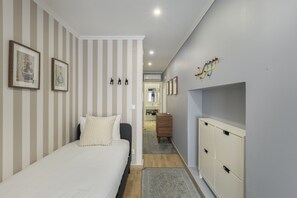 Ein Schlafzimmer mit einem Bett, einer Kommode und einem Flur, der zu einem Badezimmer führt.