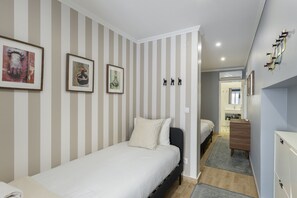 Une chambre à coucher avec un lit, une commode et un miroir.