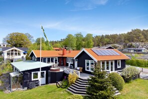 Ein Wohnhaus mit einer großen Terrasse, einer Sauna und einem Solardach.