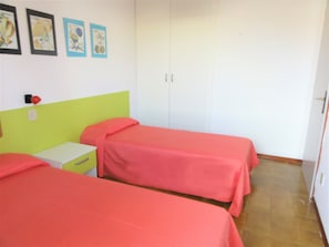 A room with two beds, a nightstand, and a wardrobe. - Peaceful Village With Pool (San Michele al Tagliamento)