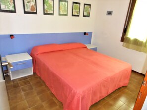 A bedroom with a bed, nightstands, a dresser, and a window with curtains. - Peaceful Village With Pool (San Michele al Tagliamento)