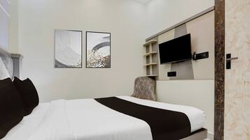 A modern bedroom with a bed, a television mounted on the wall, and two wall art pieces.