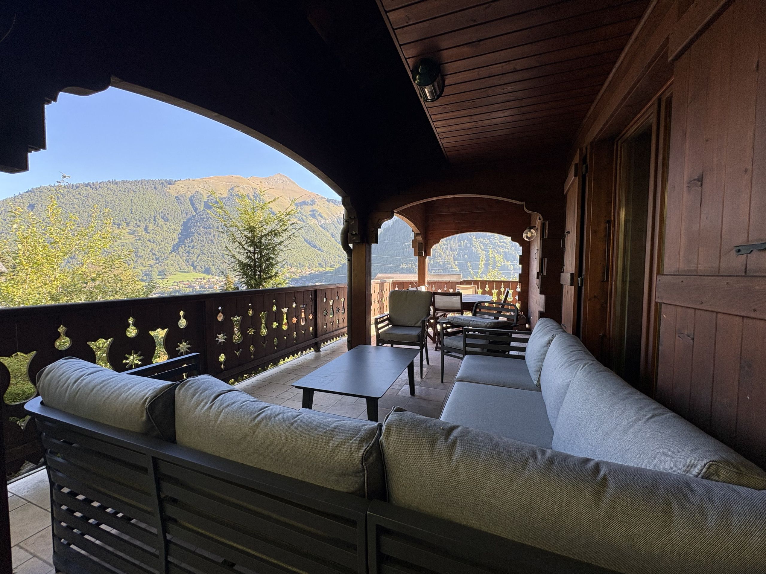 A covered outdoor seating area with a view of mountains.