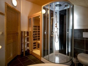 A bathroom with a glass-enclosed shower, a wooden door, and a toilet. - Chalet #12b With IR Sauna & Whirlpool (Sankt Georgen am Kreischberg)