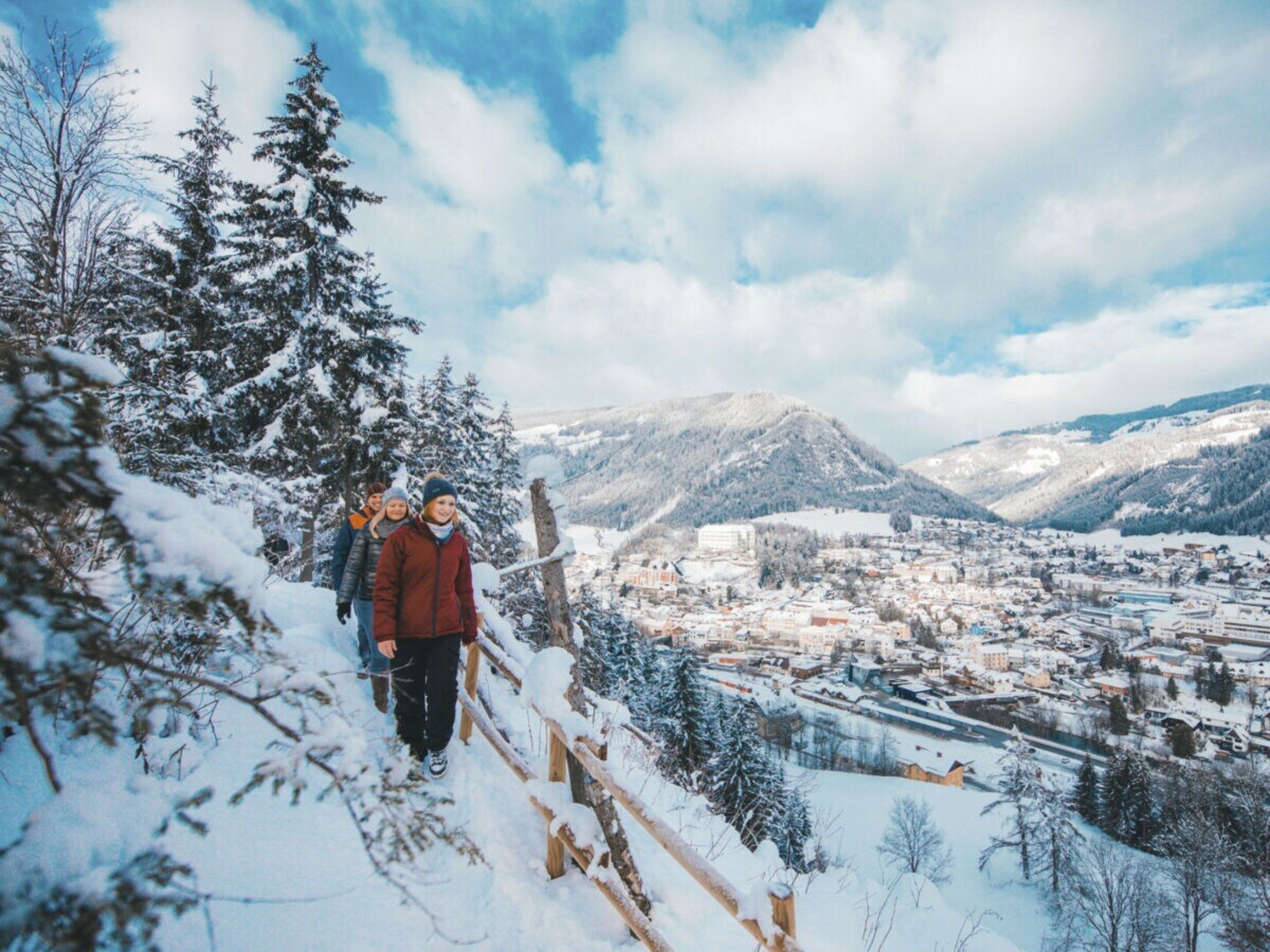A snowy mountain landscape with a town in the valley below.