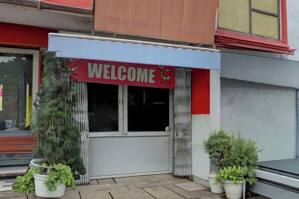 A storefront with a 'WELCOME' sign above the entrance, flanked by potted plants. - Collection O Haldwani Railway Junction (Haldwani)
