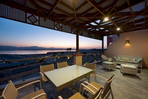 A terrace with a table and chairs, overlooking a scenic view of a body of water and mountains. - Vesta - Luxury Apt - 3BR - Marina Soma Bay (Soma Bay)