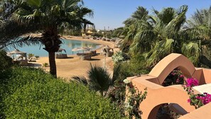 A resort with a pool, palm trees, and outdoor seating areas. - Vesta - Luxury Twin House - 3BR - Nubia (El Gouna)