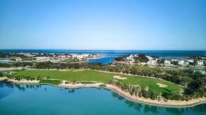 Ein Küstenresort mit Golfplatz, Strandimmobilien und einer großen Wasserfläche.