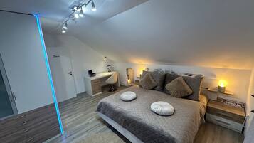 Ein modernes Schlafzimmer mit Bett, Nachttischen, Schreibtisch und Kleiderschrank.