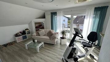 A modern living room with a sofa, coffee table, and exercise bike.