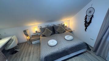 Une chambre à coucher avec un lit, des tables de chevet, un attrape-rêves et un bureau.