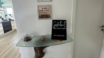 Ein modernes Interieur mit einem Glastisch, Holzfuß und Dekorationselementen.