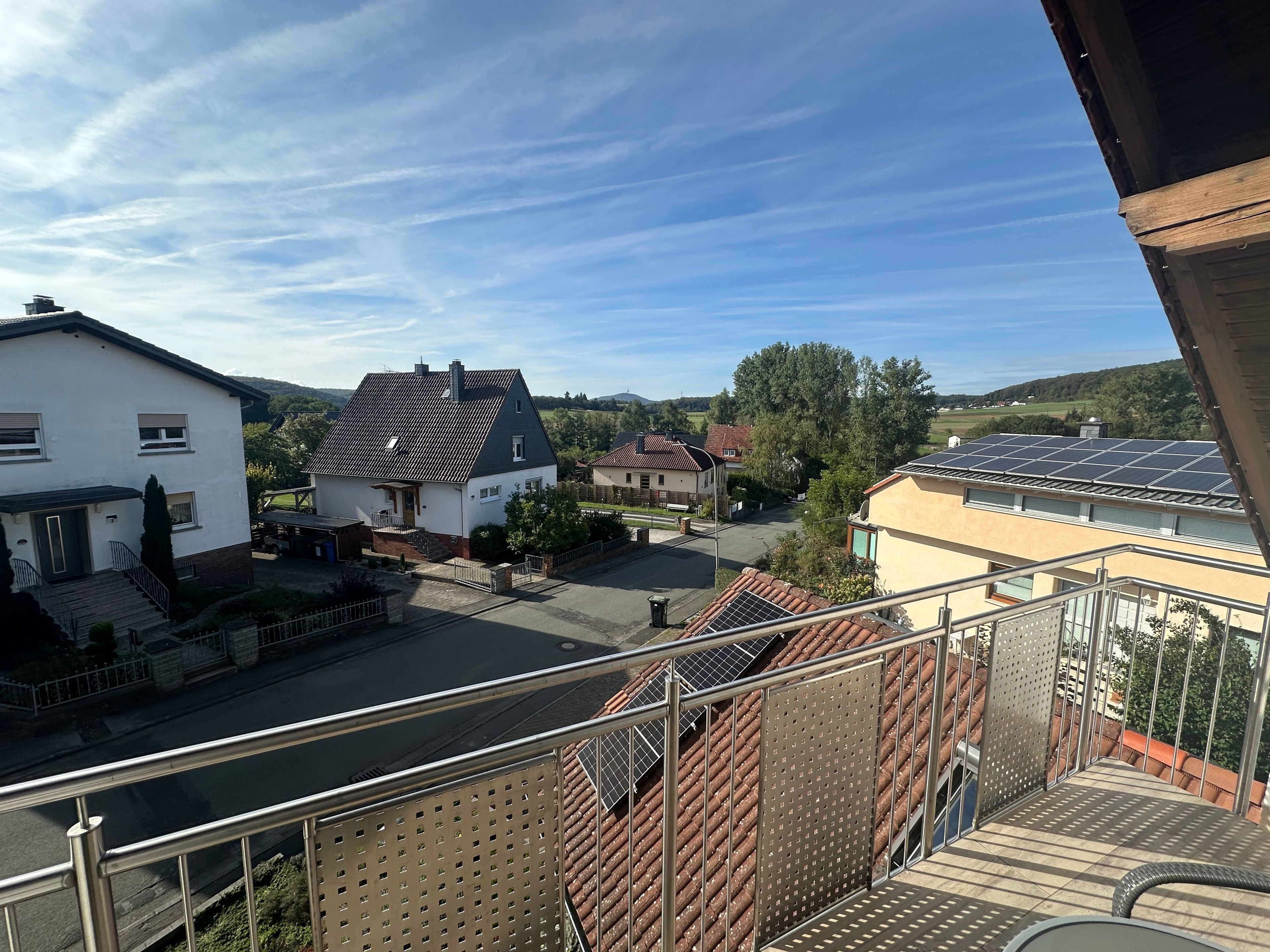 Ein Wohngebiet mit Häusern und einer Straße, bewölkter Himmel.