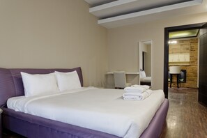 A hotel room with a large bed, a desk, and a bathroom visible through an open door. - Vesta - Luxury APT - 3BR - South Academy III (New Cairo)